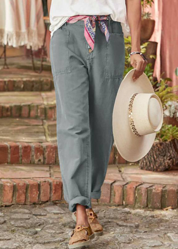 Pantalon élégant gris, fermeture boutonnée, poches et bas légèrement retroussé.