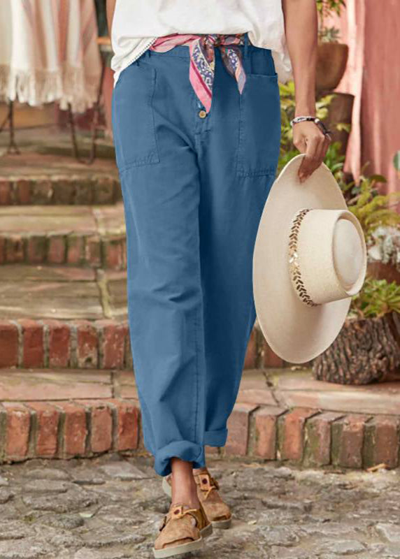 Pantalon élégant bleu, fermeture boutonnée, poches et finitions aux chevilles.