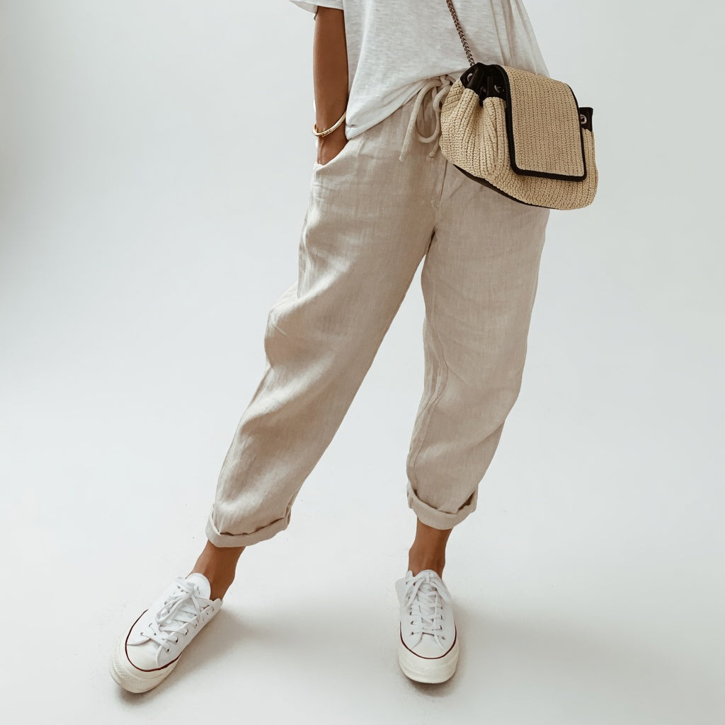 Pantalon fluide beige en mélange coton et lin, coupe ample, chevilles élastiquées.