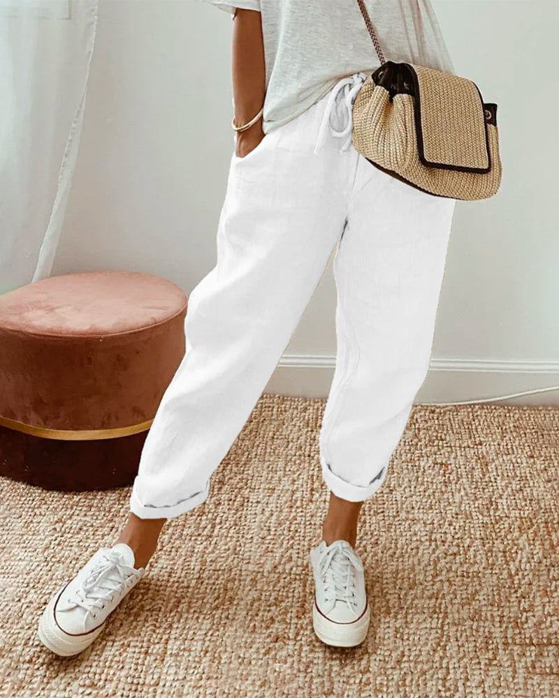 Pantalon fluide blanc en mélange coton et lin, coupe ample, chevilles élastiquées.