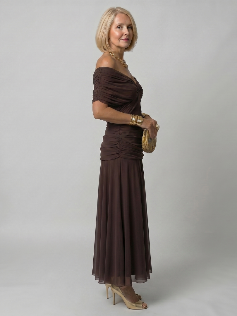 Robe longue brune à épaules dénudées, taille froncée, jupe fluide évasée.