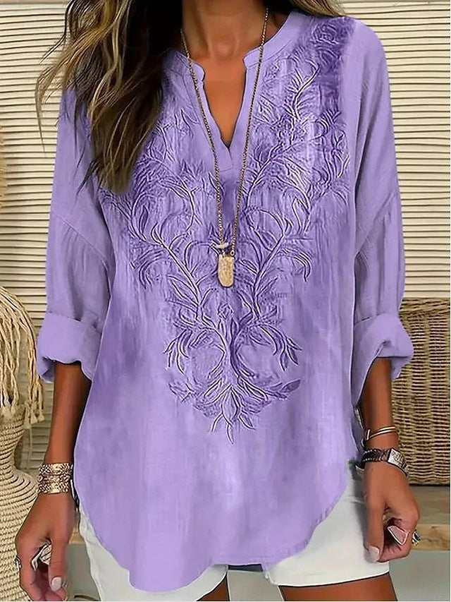 Blouse violette ample à broderie florale ton sur ton, encolure V boutonnée.