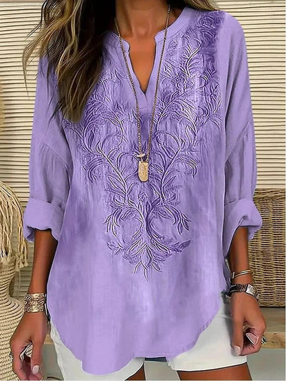 Blouse violette ample à broderie florale ton sur ton, encolure V boutonnée.