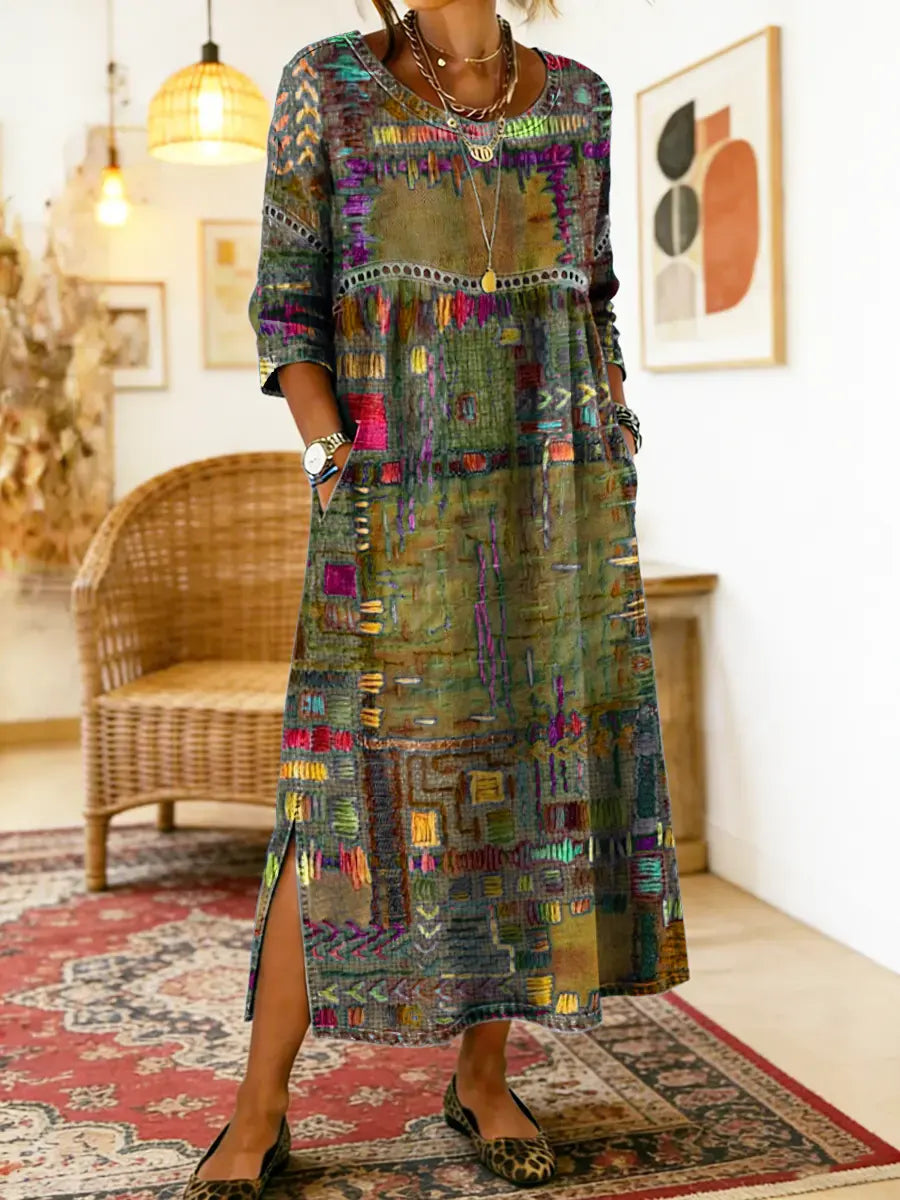 Robe longue aux motifs patchwork ethnique, fond gris foncé, encolure ronde, fente latérale.