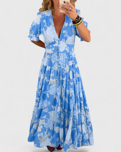 Robe longue bleue fleurie à col V, manches bouffantes, taille froncée.