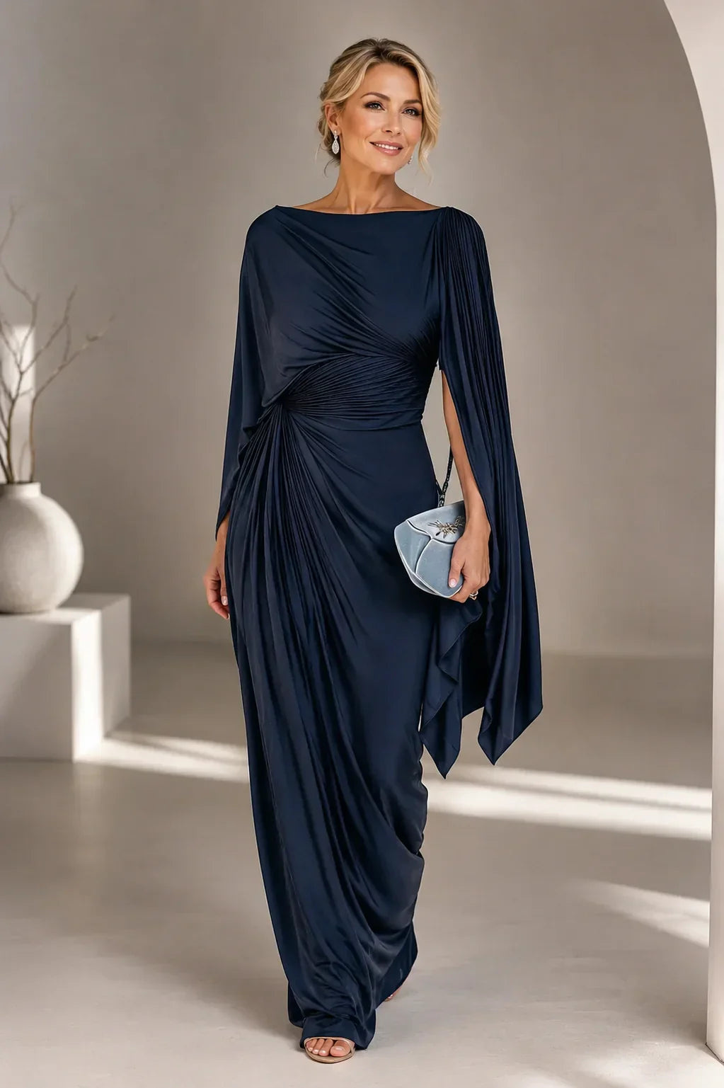 Robe longue plissée bleu marine, drapée au buste, manches cape, jupe fluide avec découpe.