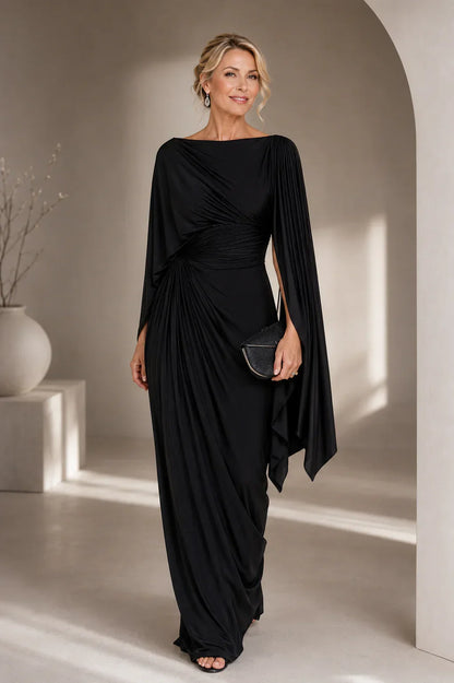 Robe longue plissée noire, drapée au buste, manches cape, découpe asymétrique sur le côté.