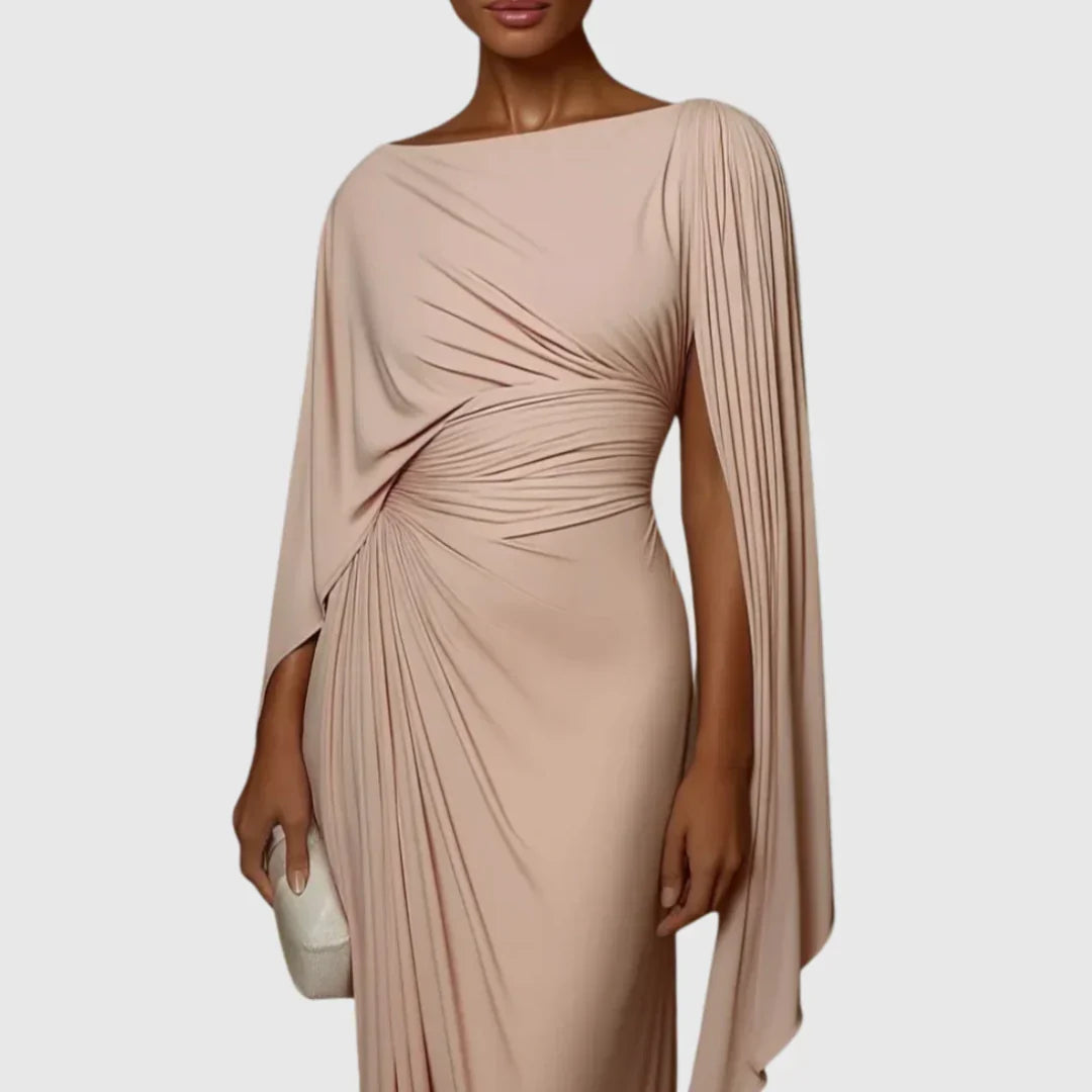 Robe longue plissée rose poudré à encolure bateau, drapée, manches cape épaules.