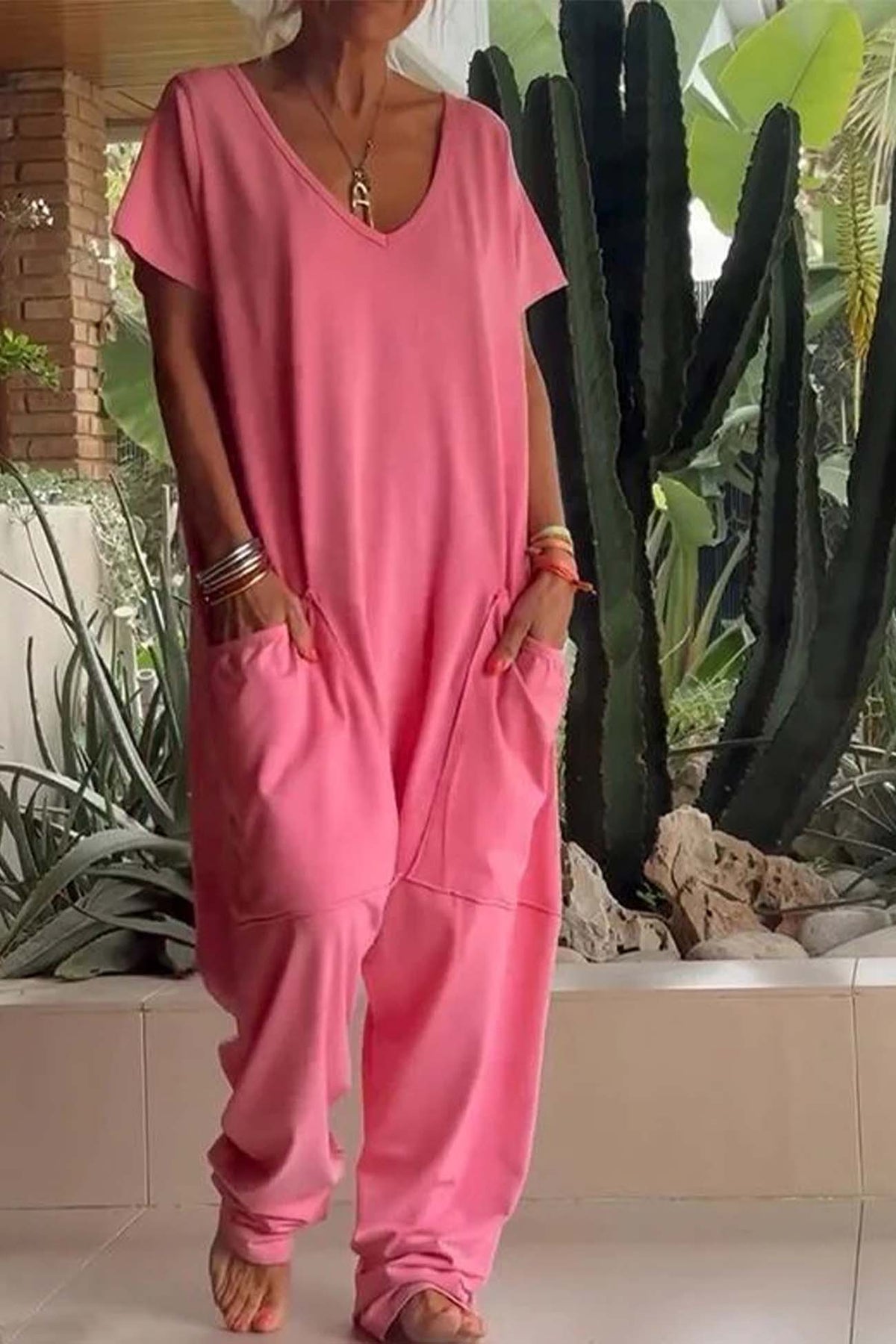 Combinaison décontractée rose corail, encolure V, manches courtes, poches kangourou et jambes larges.