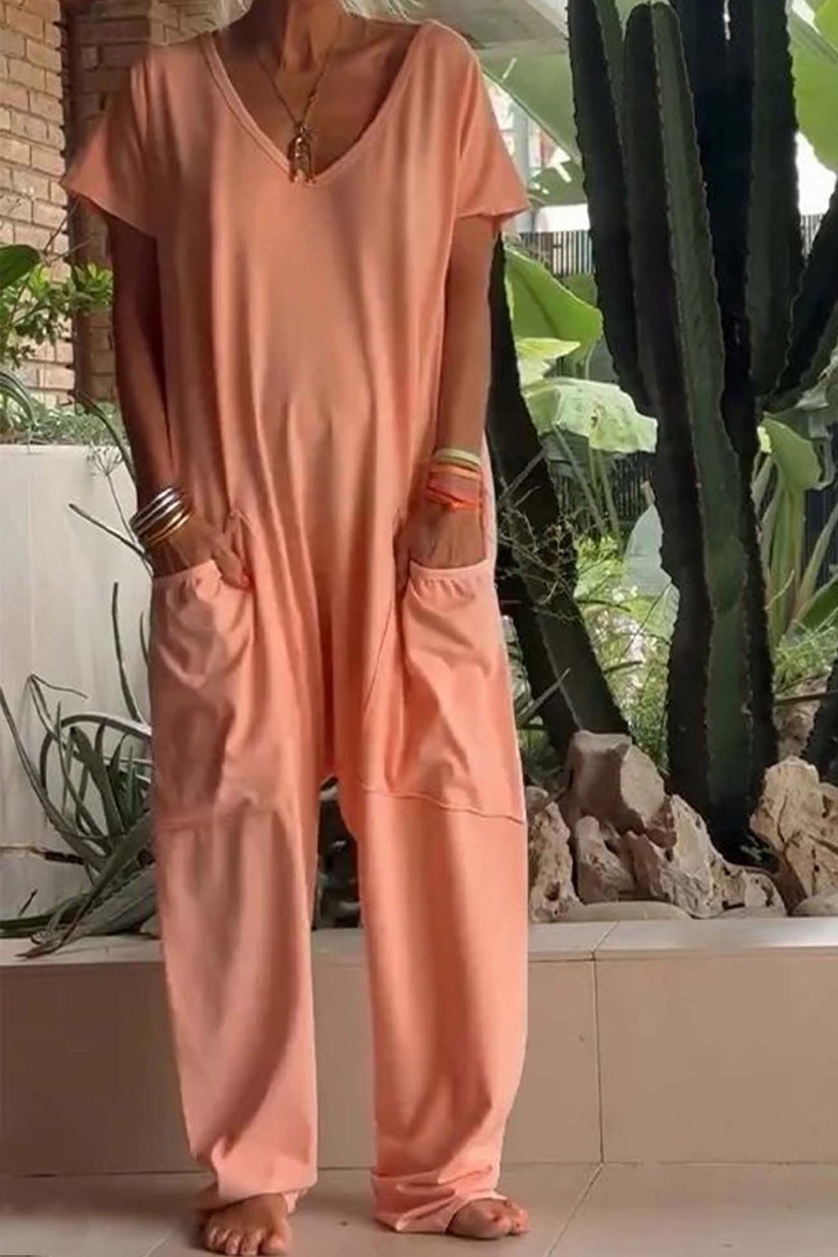 Combinaison décontractée rose pêche, encolure V, poches avant, manches courtes et pantalon ample.
