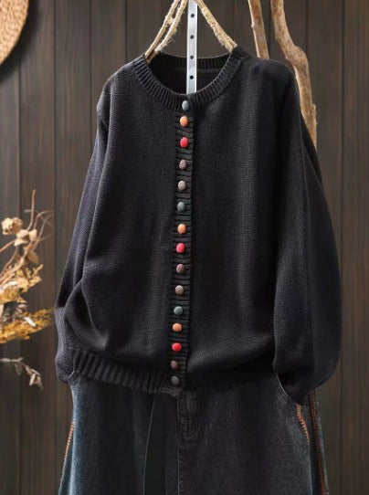 Gilet en maille noire à col rond, rangée de boutons multicolores et ourlet côtelé