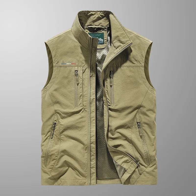 Gilet sans manches kaki, col montant, fermeture zippée et poches zippées.
