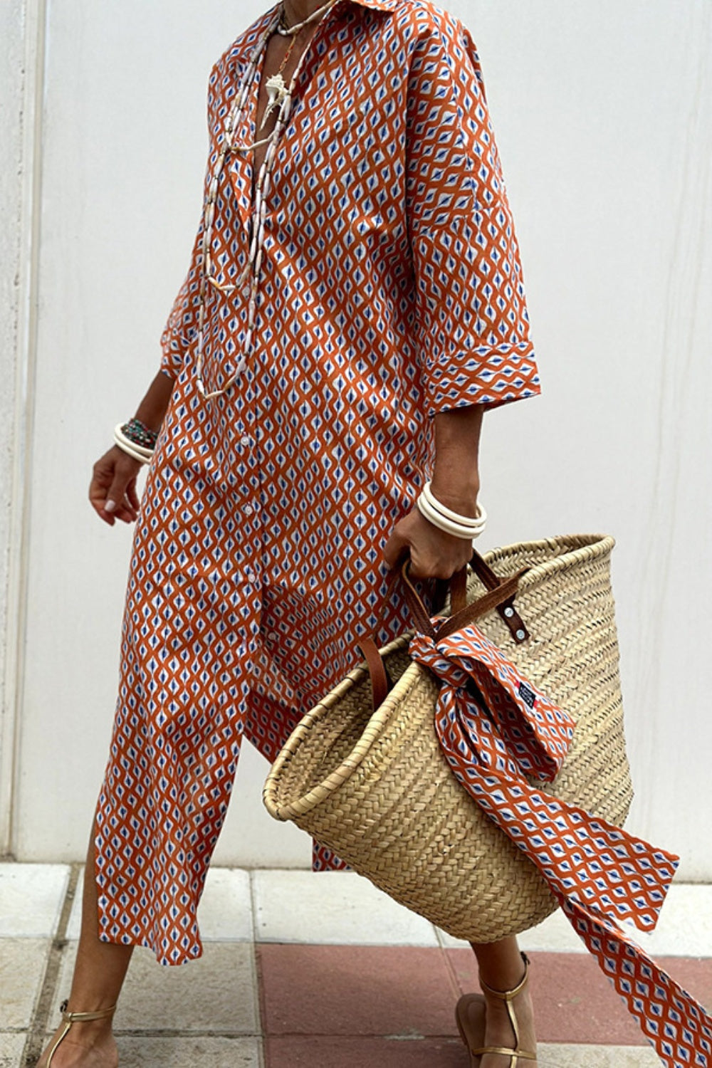 Robe chemise à motifs orange et blanc, manches trois-quarts, fente latérale, ceinture.