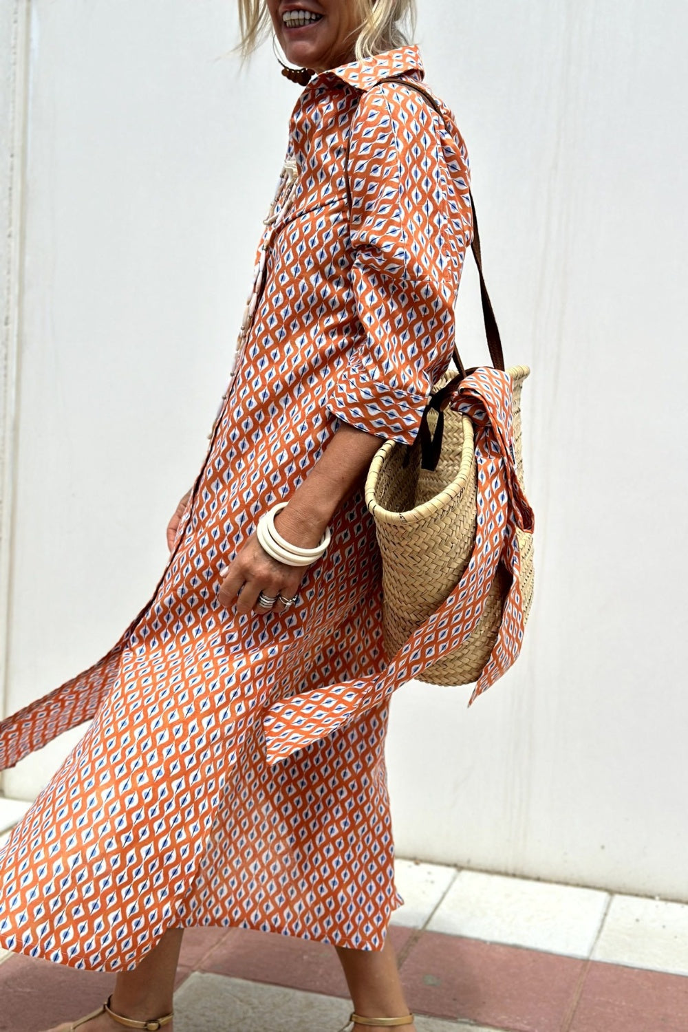 Robe chemise à motifs losanges orange et blanc, manches trois-quarts, col ouvert.