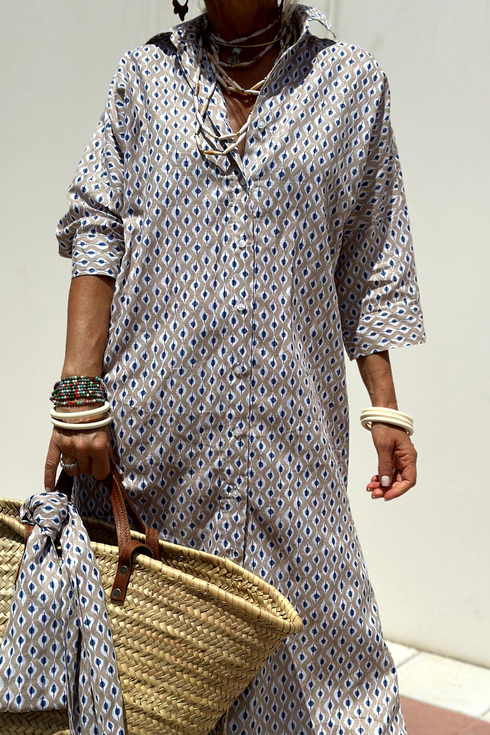 Robe chemise à motifs losanges bleu clair et blanc, col ouvert, manches retroussées.