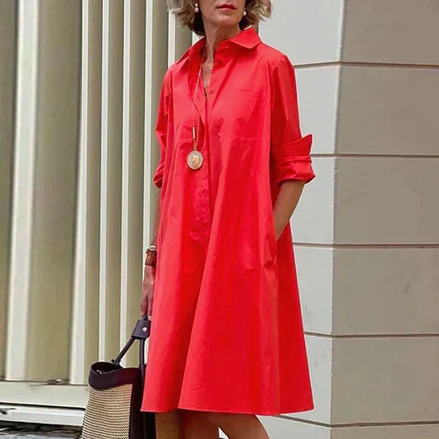 Robe mi-longue rouge vif à col chemise, boutonnage devant et manches retroussées.