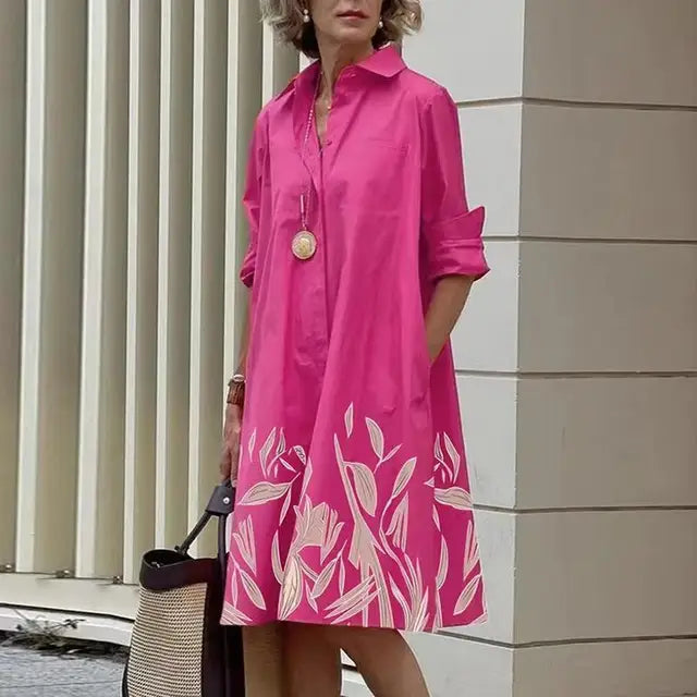 Robe mi-longue fuchsia à imprimé floral blanc en bas, col chemise boutonné.