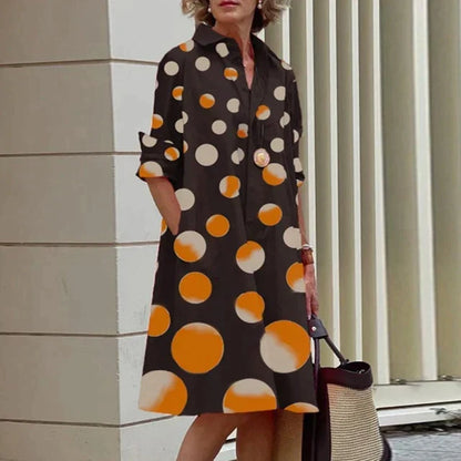 Robe noire mi-longue à gros pois orange et blancs, col chemise boutonné.