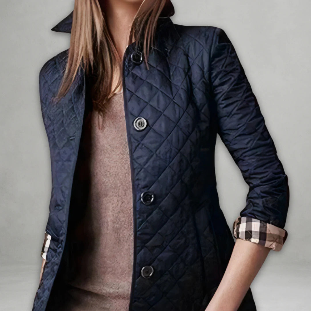 Veste légère matelassée bleu foncé à col simple, boutonnage et poignets à carreaux.