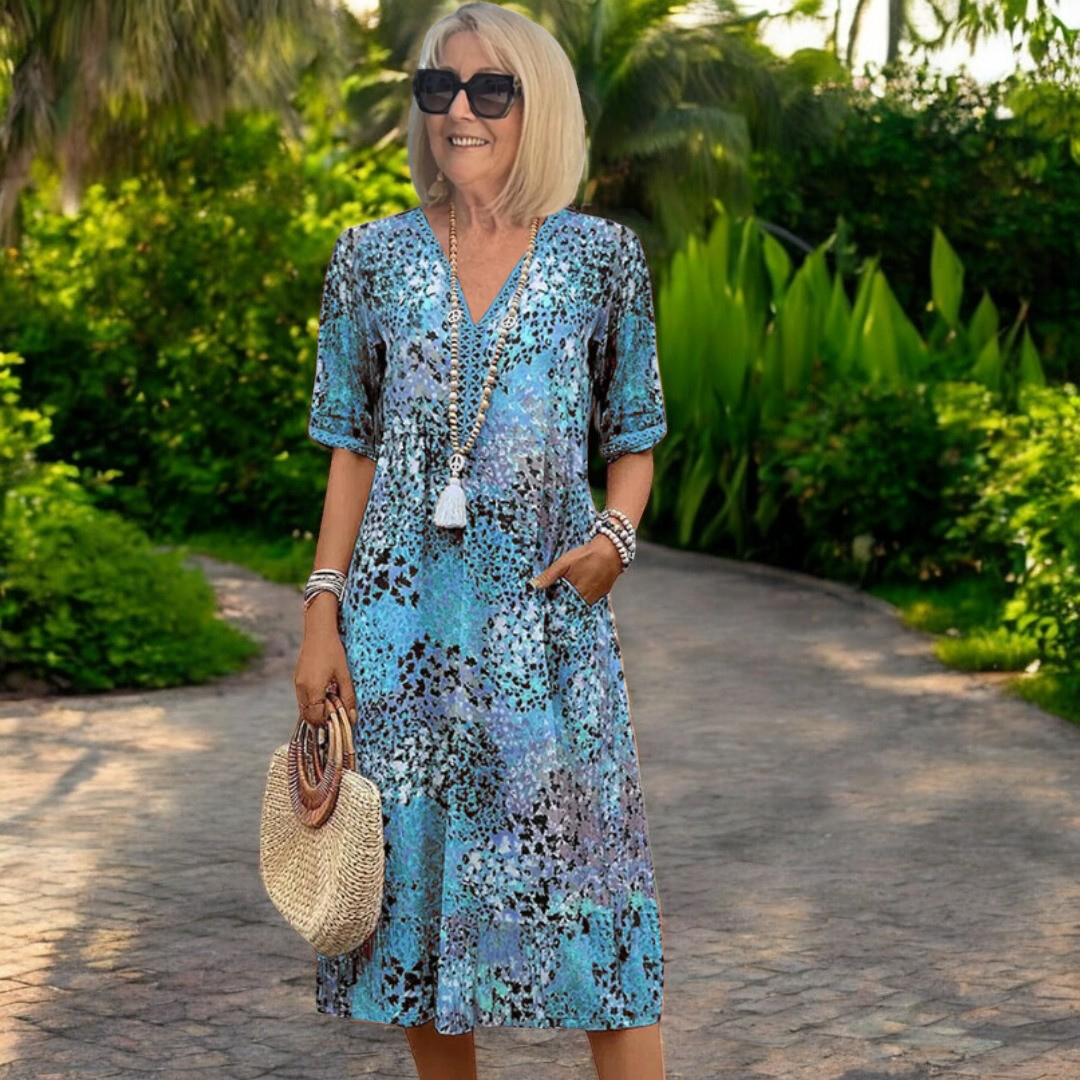 Robe longue encolure V, manches courtes, imprimé multicolore bleu, avec pompon décoratif.