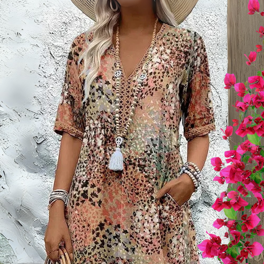 Robe longue encolure V, manches courtes, imprimé multicolore sur base beige, avec pompon.