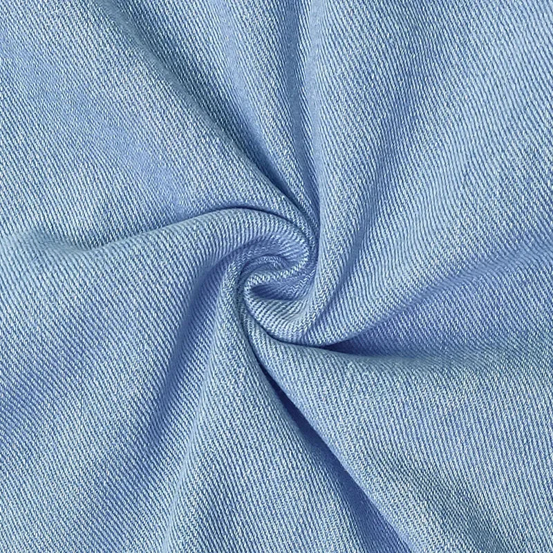 Tissu de robe en jean bleu clair, gros plan sur la texture et la surpiqûre.