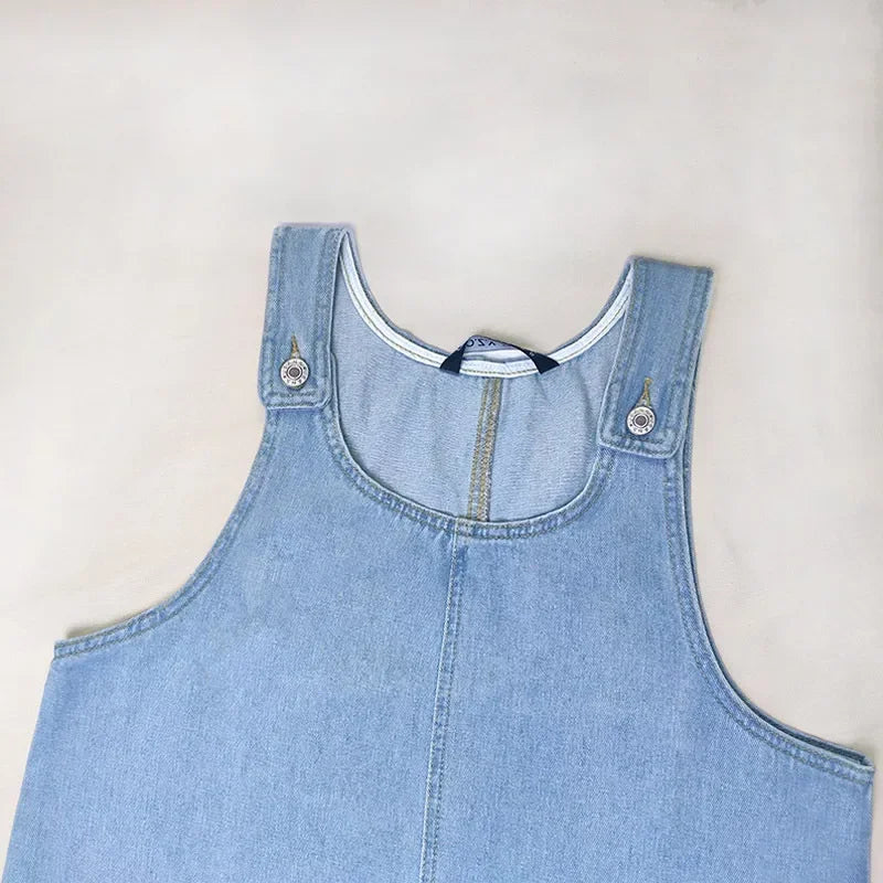 Haut de robe en jean bleu clair sans manches, col rond et passant de bouton-pression.