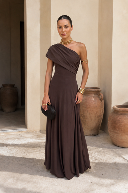 Robe marron foncé à un épaule drapée, jupe évasée fluide, décolleté asymétrique.