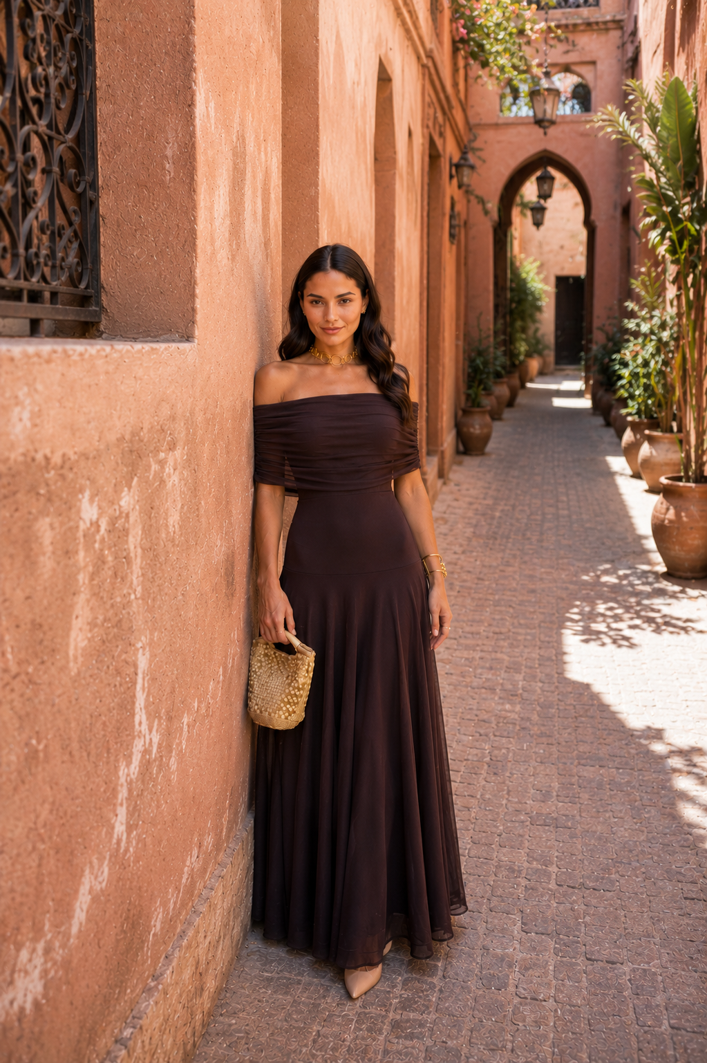 Robe longue marron foncé décolleté asymétrique, épaules en biais drapées, jupe fluide.