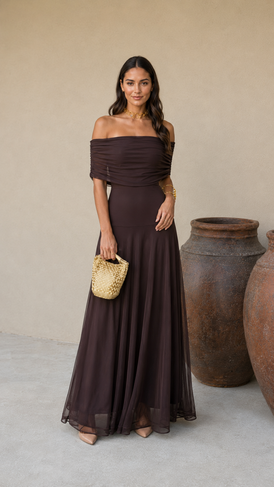 Robe longue marron foncé off-shoulder, drapés au buste, jupe fluide et évasée.