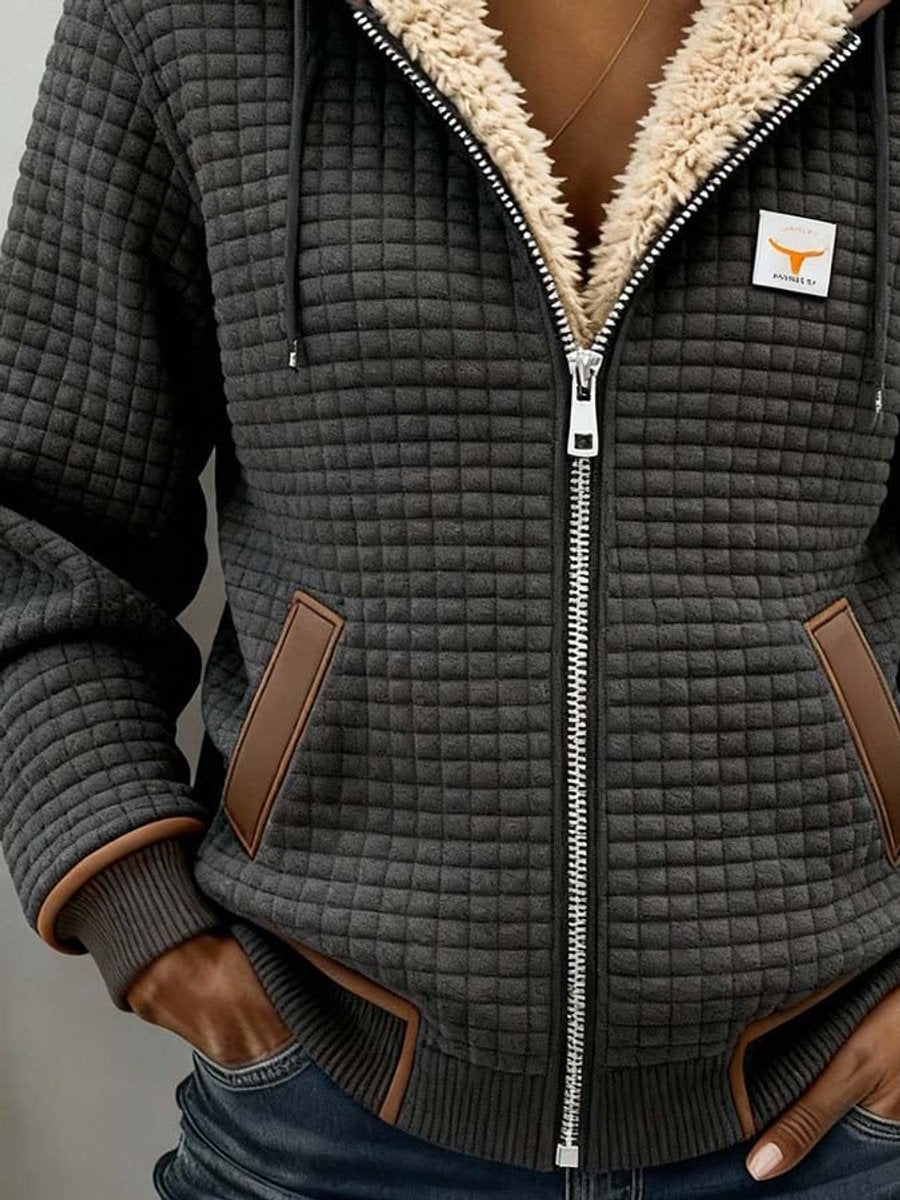 Veste sherpa à capuche gris foncé, zip blanc, poches passepoilées marron.