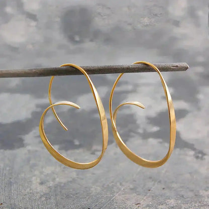 Boucles d’oreilles pendantes spirales ouvertes dorées, grands anneaux ovales.