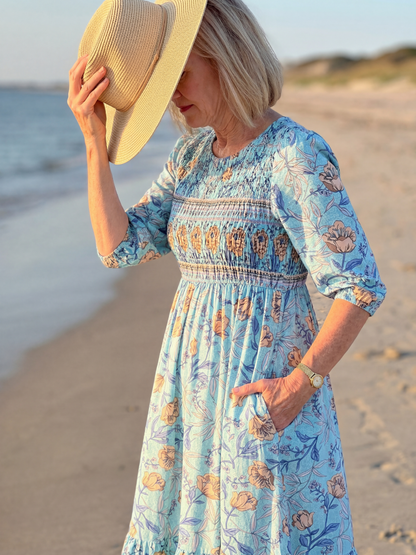 Robe midi bleue à fleurs, manches trois-quarts, taille froncée, vue de côté