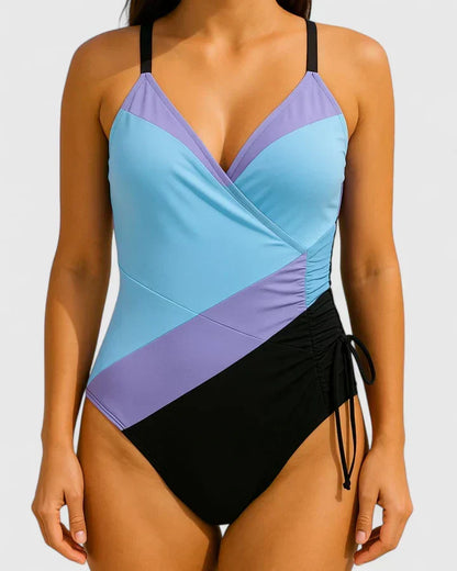 Maillot de bain une pièce bleu clair et violet, décolleté cache-cœur, cordon à la taille.
