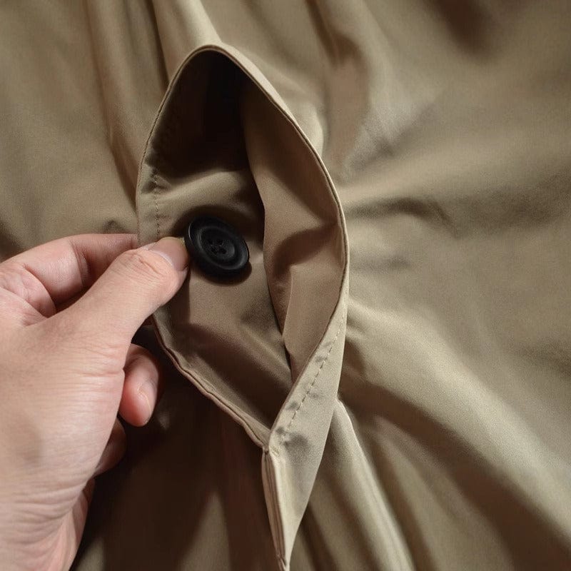 Détail manche de trench-coat kaki : patte boutonnée au poignet et tissu de col