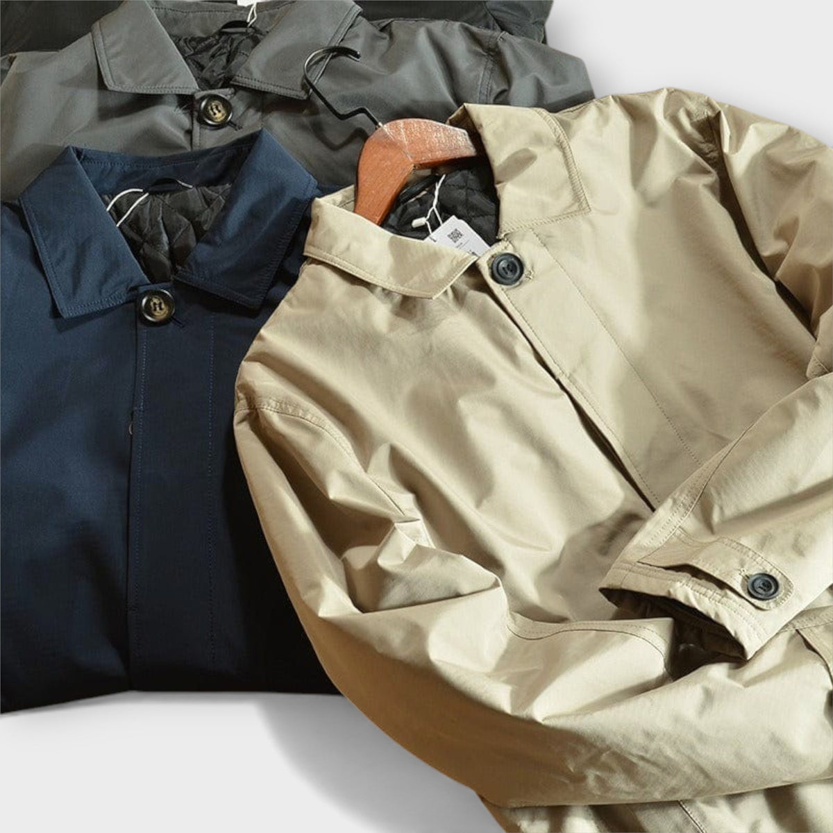 Trench-coat kaki sur cintre, fermeture pression/bouton et poignets à patte