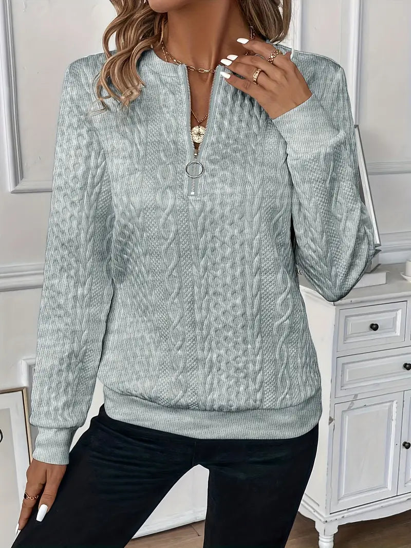 Pull à glissière gris clair à motif torsadé, col montant, fermeture éclair centrale.