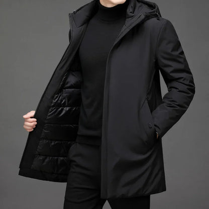 Veste longue d’hiver noire à capuche, fermeture zippée, poches latérales, doublure matelassée.