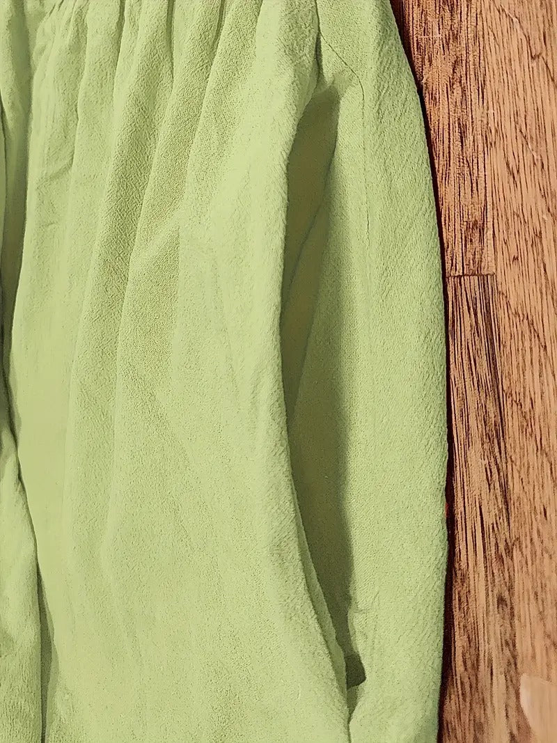 Tissu de robe vert, texture légère et couture sur le côté