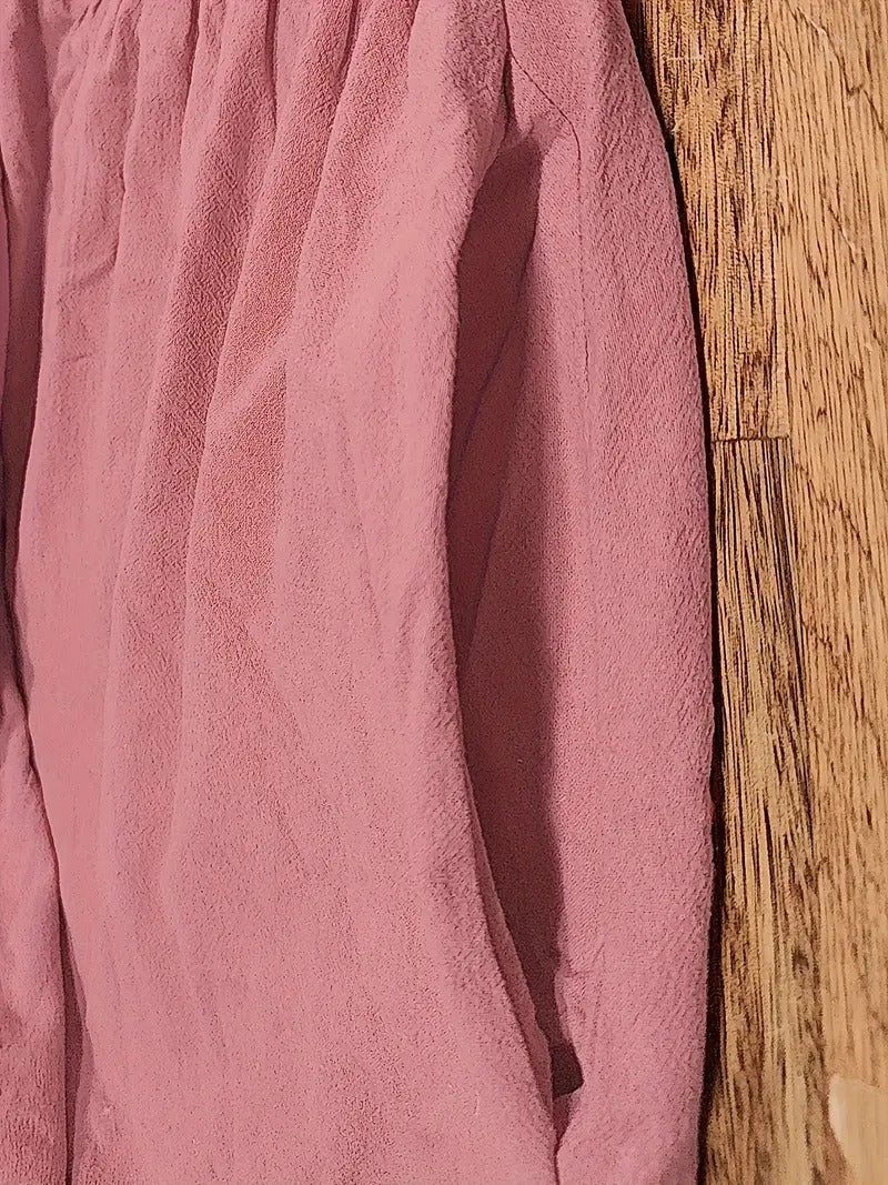 Tissu de robe rose, texture froissée et couture latérale visible