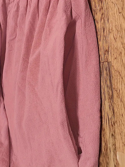 Tissu de robe rose, texture froissée et couture latérale visible