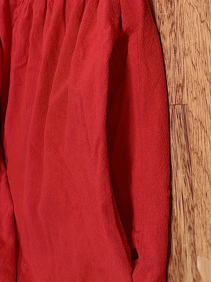 Tissu de robe rouge texturé avec plis et coutures