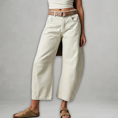 Jean baggy blanc cassé, poches avant, ceinture marron et ourlet droit.