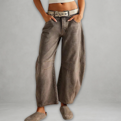 Jean baggy gris-brun délavé, taille avec ceinture, poches et coutures renforcées.