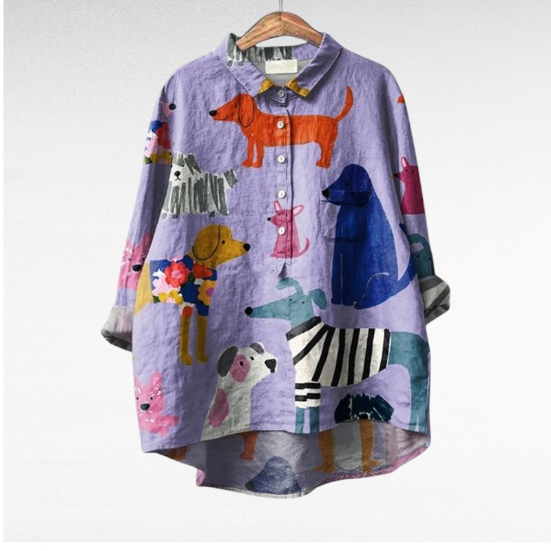 Blouse en tissu violet à motifs d’animaux, col chemise et boutons visibles.