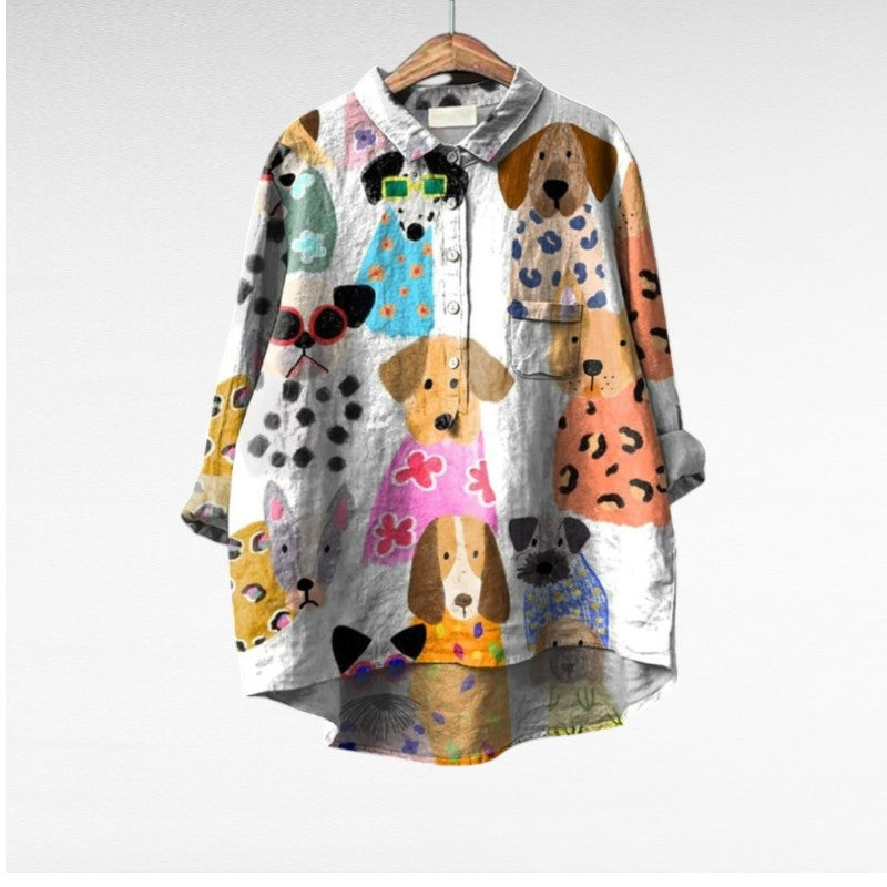 Blouse blanche à motifs d’animaux multicolores, col chemise et boutons visibles.
