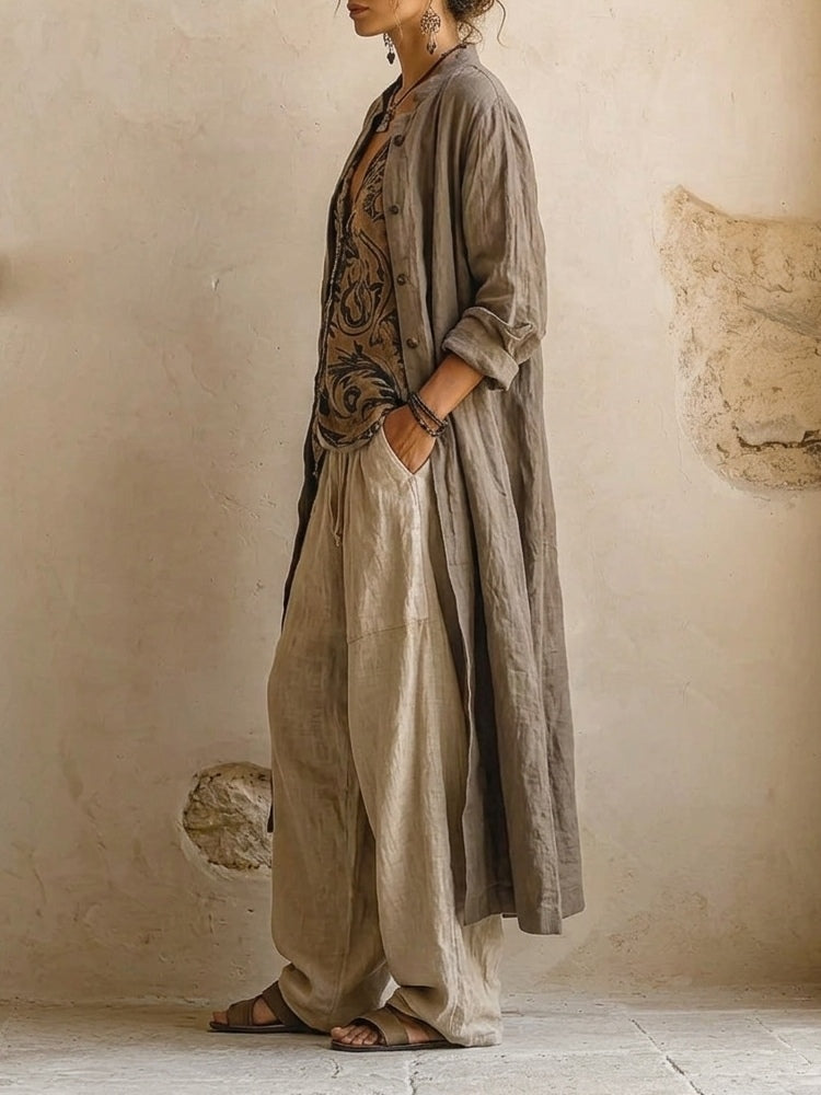 Ensemble en lin : veste longue kaki ouverte sur top imprimé et pantalon écru ample.