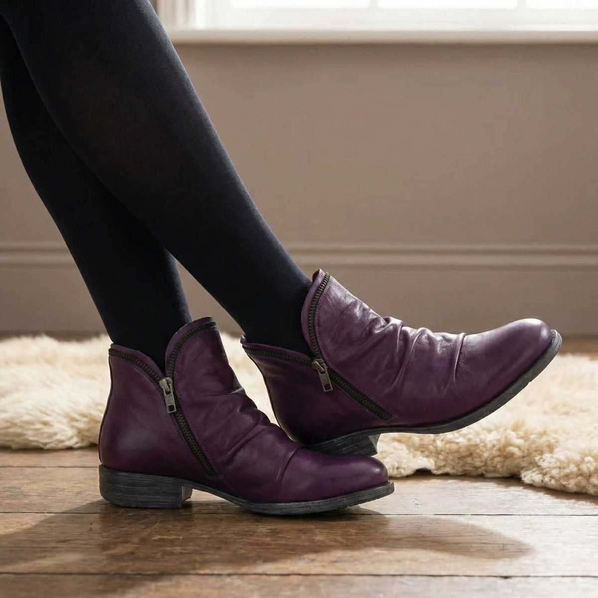 Bottines violet foncé à fermeture éclair, portées avec collant noir, talon bloc