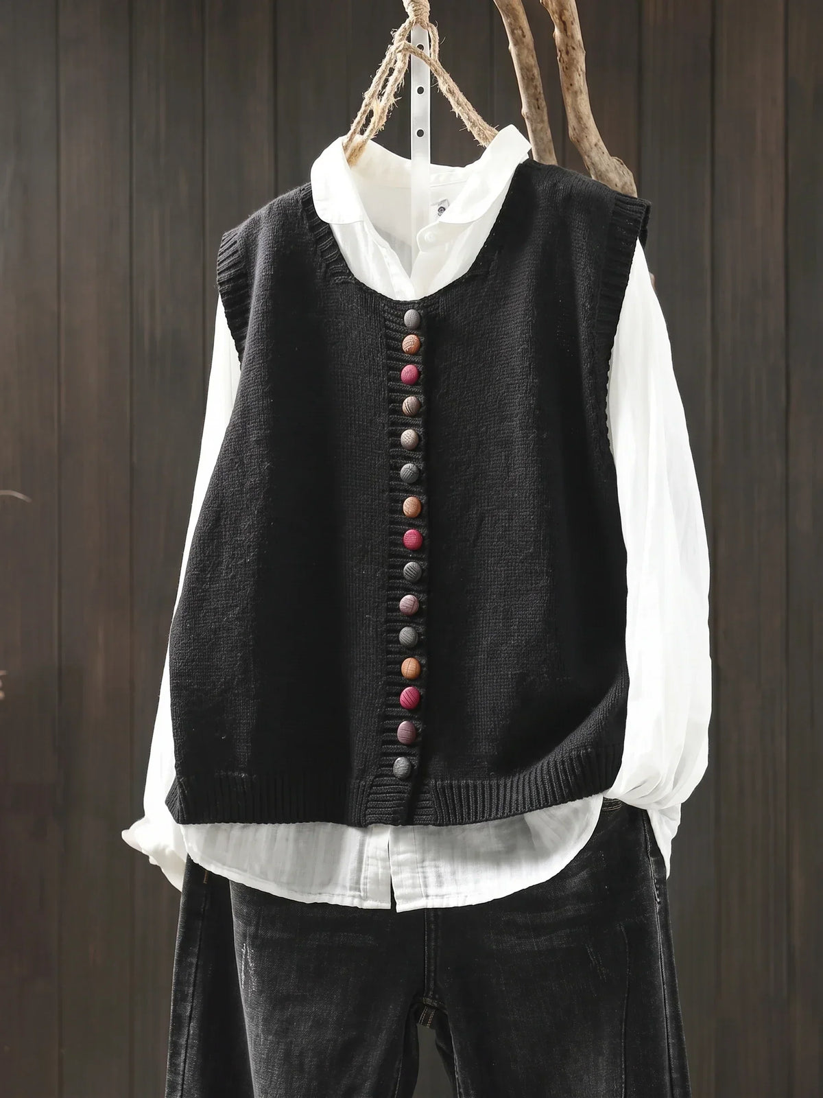 Gilet sans manches en maille noire à col rond, rangée de boutons décoratifs